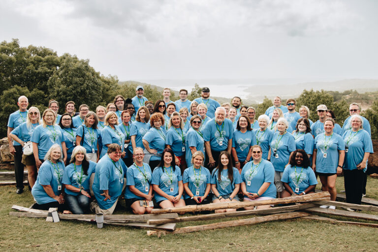 Entire Myers Davis team in blue shirts standing outside